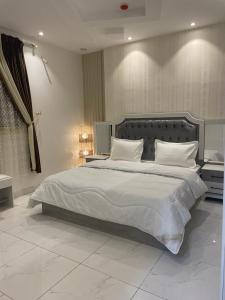 a bedroom with a large bed with white sheets and pillows at منتجع قرية الريف الفندقية in Taif