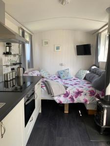 a small room with two beds in a caravan at Tides Reach, Deluxe Shepherds hut, 100m from the Beach in Saint Merryn