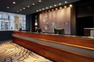 a lobby with a bar with a large screen at Le Méridien Munich in Munich