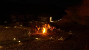 Un groupe de gens autour d'un feu la nuit dans l'établissement Desert Jewel Camp, à Wadi Rum