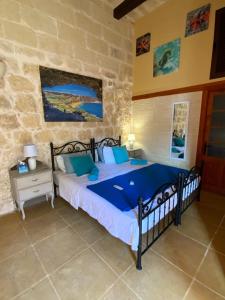 - une chambre avec un lit dans un mur en pierre dans l'établissement Gozo Sunset Farmhouse, à Qala