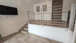 a room with stairs and a flat screen tv at Il Corbezzolo Tropea Residence in Tropea