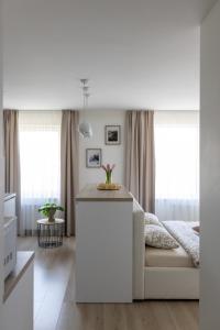 um quarto branco com uma cama e 2 janelas em Harmony em Jelgava