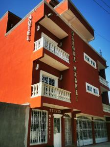 - un bâtiment rouge avec un balcon blanc dans l'établissement Hotel Boutique Casona Mashei, à Tasquillo