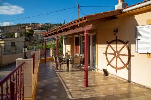 a house with a patio with a wheel on it at Martha's House Kefalonia in Valsamáta