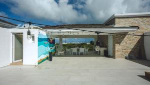 uma pérgola branca com uma mesa e cadeiras num pátio em Beach View PH Jacuzzi in Hard Rock Golf em Punta Cana