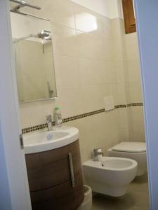 W łazience znajduje się umywalka, toaleta i lustro. w obiekcie locazione Mery w Wenecji