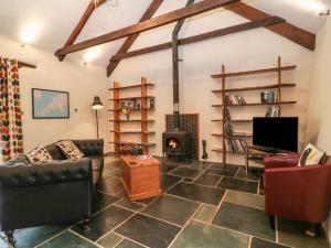 a living room with a couch and a fireplace at The Threshing Barn in Beaworthy