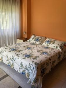 a bedroom with a bed with a floral bedspread at Appartamento Il Giardino in Castello dellʼAcqua