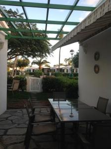 a patio with a table and chairs under a roof at Bungalow Maspalomas in Maspalomas