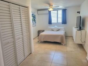 a bedroom with a bed and a flat screen tv at Steps to the Beach l Private Apt Stay l Parking WiFi Nightlife in San Juan