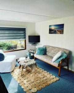 sala de estar con sofá y mesa en Knus chalet met zwembad en sauna, en Sint Maartensvlotbrug