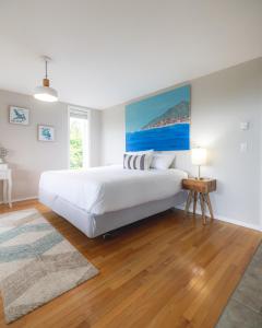 um quarto branco com uma cama grande e uma mesa em By the Bay Lavender Villa em Chemainus