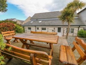 a wooden picnic table and benches in a yard at Bryn Goleu in Moelfre