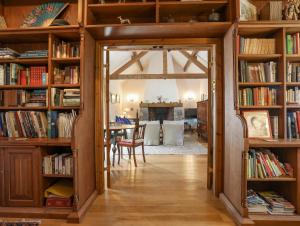 a room with bookshelves and a dining room at Llo Bach in Abergele
