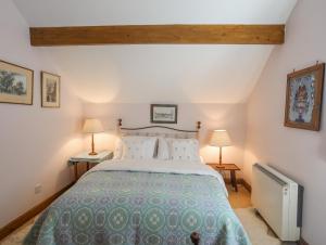 a bedroom with a large bed and two lamps at Llo Bach in Abergele