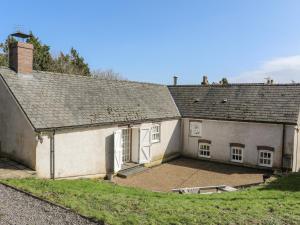 an old white house with a large courtyard at Llo Bach in Abergele