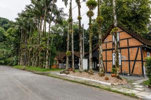 a house on the side of a road with palm trees at Casa enxaimel em Pomerode in Pomerode