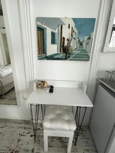 mesa blanca y taburete en una habitación con espejo en Cozy Studio Mykonos Town, en Mykonos ciudad