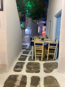 un ristorante con tavoli e sedie su un pavimento in pietra di Cozy Studio Mykonos Town a Mykonos Città