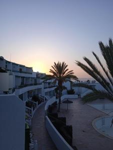 a view of a beach with palm trees and buildings at Blue View Hermoso Apartamento Remodelado Ubicación Ideal in Costa Teguise