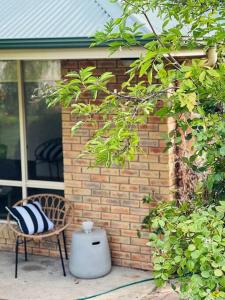 a chair and a trash can next to a brick wall at Richmond Cottage in Richmond