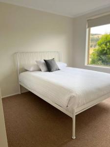 a white bed in a room with a window at Richmond Cottage in Richmond