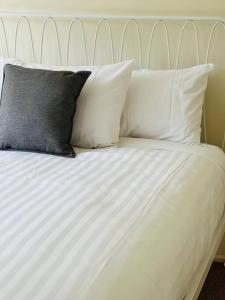 Una cama blanca con cuatro almohadas. en Richmond Cottage, en Richmond