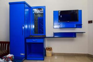 a blue cabinet with a tv in a room at The Royal Sea Clifton in Karachi