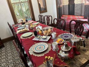 una mesa con un mantel rojo con comida. en 1001 Nights Historic Bed and Breakfast Adults Only, en St. Augustine