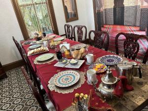 a table with a red table cloth with food on it at 1001 Nights Historic Bed and Breakfast Adults Only in St. Augustine
