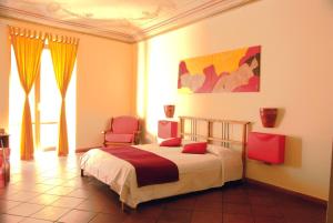 ein Schlafzimmer mit einem Bett und zwei Stühlen darin in der Unterkunft LT Appartamento Teatro Massimo in Palermo