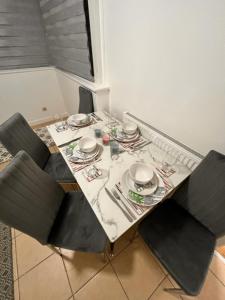 a dining room table with chairs and a table with plates and dishes at Archway Islington London in London