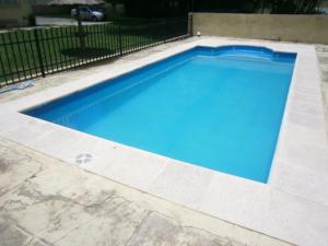 a swimming pool with blue water in a yard at Hotel Nuevo Fatica in Villa Carlos Paz