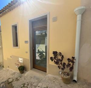 una puerta de una casa con dos macetas en Casa Shekelesh, en Scicli