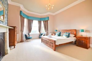 1 dormitorio con 1 cama grande y chimenea en Clevelands Country House Holiday Rental 10 Guests en Wroxall