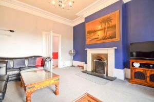 a living room with a couch and a fireplace at Clevelands Country House Holiday Rental 10 Guests in Wroxall