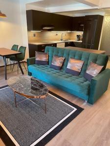 uma sala de estar com um sofá azul e uma mesa em The Park House Suite, Jakobstad em Pietarsaari