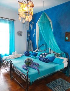 a blue bedroom with a bed with blue walls at Athina-Milina in Milína