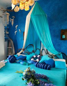 梅琳納的住宿－Athina-Milina，蓝色卧室,配有一张带天蓬的床