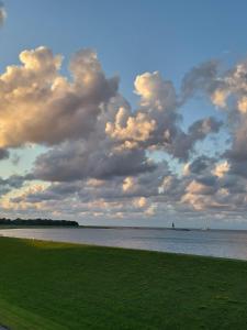 un ciel nuageux au-dessus d'une masse d'eau dans l'établissement Ferienwohnung mit Seesicht Grimmershörnbucht, à Cuxhaven