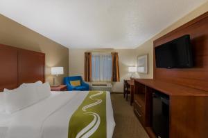 a hotel room with a bed and a flat screen tv at Quality Inn in Marysville