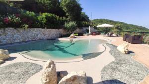 una piscina con rocce in un cortile di Il Corbezzolo Tropea Residence a Tropea