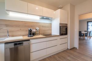 una cocina con armarios blancos y fregadero en Appartement de standing, en Albertville