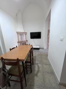 een eetkamer met een tafel en stoelen en een tv bij La casa dei Nonni in Parabita