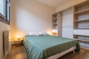 1 dormitorio con 1 cama en una habitación con estanterías en Appartement de standing, en Albertville
