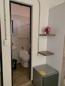 a bathroom with a toilet and a sink at La Curva Apartamentos in Cali
