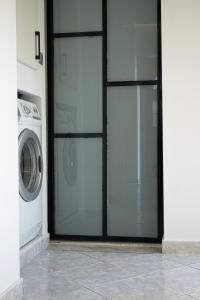 una porta a vetri con lavatrice in una casa di Thalia apartments a Kalamáta