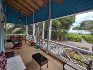 a screened in porch with a view of the beach at Serenity Beach Cottages in Utila