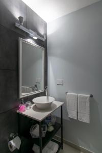 y baño con lavabo, espejo y toallas. en Franca Estadías Temporarias en Rosario